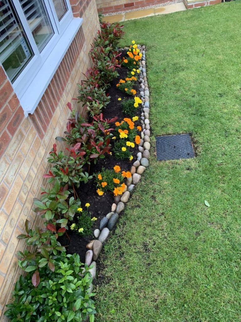 Newly planted front garden flowerbed completed after dark with a head torch, showing how ADHD time blindness can lead to night-time productivity surges.